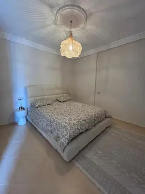 a bedroom with a bed and a chandelier at Villa moderne avec jacuzzi & jardin - Marrakech in Marrakech
