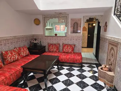a living room with a red couch and a table at Riad Zaitone 146 in Marrakech