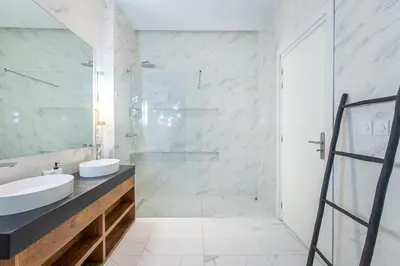 a bathroom with a sink and a glass shower at Villa Safiya, Piscine Chauffée & jeux in Marrakech