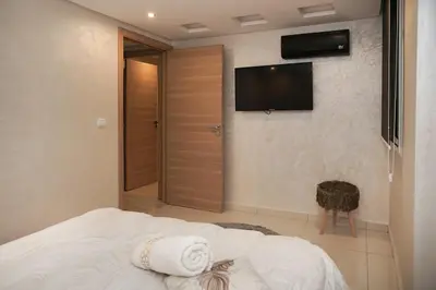 a bedroom with a bed with a television on the wall at Apartment for rent ,Duplex in Marrakech