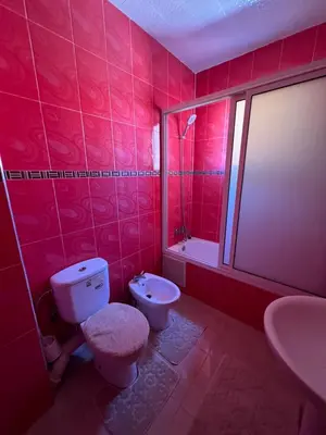 a red bathroom with a toilet and a sink at Marrakech gulize in Marrakech