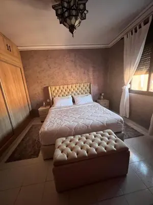 a bedroom with a large bed with a tufted footboard and a couch at Marrakech gulize in Marrakech