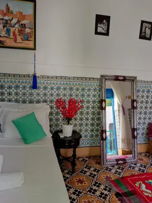 a bedroom with a bed and a mirror and a table at Riad Dar Medina Land in Marrakech