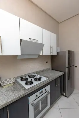 a kitchen with a stove and a refrigerator at Elegant and Modern Apartment, Calm Cosy and Central in Marrakech