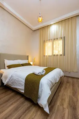 a bedroom with a large bed and a window at Elegant and Modern Apartment, Calm Cosy and Central in Marrakech