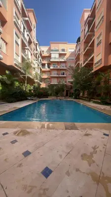 an empty swimming pool in front of a building at Un oasis au cœur de la ville, Rouge in Marrakech
