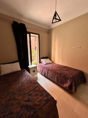 a bedroom with two beds and a window at Cosy urbain in Marrakech