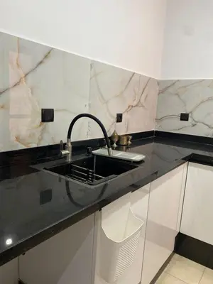 a kitchen with a sink and a black counter top at Cosy urbain in Marrakech