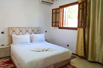 a bedroom with a white bed with a robe on it at Marrakesh villa 1 in Marrakech