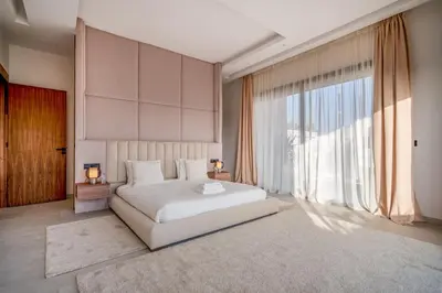 a bedroom with a white bed and a large window at Villa Bahia Luxury-Pool Breakfast & Golf Access in Marrakech