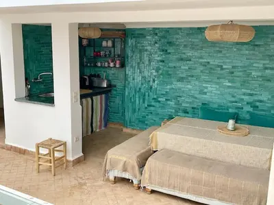 a bedroom with two beds and a green wall at Riad zouine dans un quartier traditionnel in Marrakech