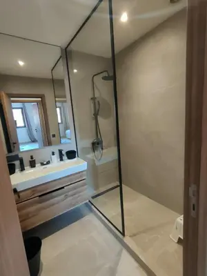 a bathroom with a shower and a sink and a mirror at Appartement à Guéliz avec belle terrasse in Marrakech