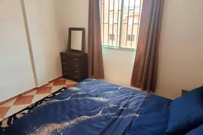 a bedroom with a blue bed and a mirror at Appartement familial in Marrakech