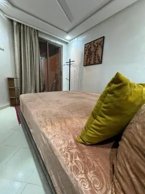 a bedroom with a bed with a green pillow on it at Apartment in Marrakech in Marrakech