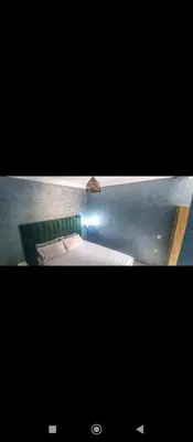 two pictures of a bed in a room at Appartement DUPLEX in Marrakech