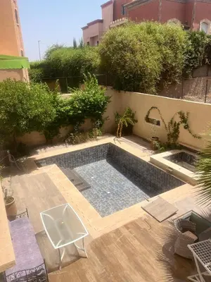a swimming pool in the middle of a garden at Studio avec SDB salon tele kitchenette privé dans une villa piscine, calme et commodités in Marrakech