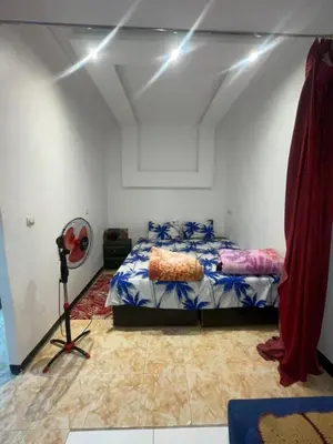 a bedroom with a bed and a fan at Suite 2 in Marrakech