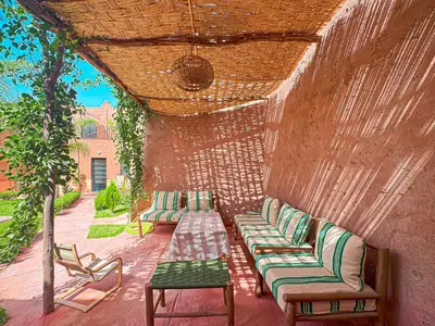 a patio with couches and chairs on a brick wall at Évasion Douce avec jardin, terrasse et piscine privée in El Aggada