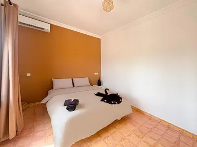 a bedroom with a bed with two bags on it at Évasion Douce avec jardin, terrasse et piscine privée in El Aggada