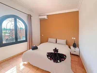 a bedroom with a bed with a dress on it at Évasion Douce avec jardin, terrasse et piscine privée in El Aggada