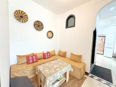 a living room with a couch and a table at Évasion Douce avec jardin, terrasse et piscine privée in El Aggada
