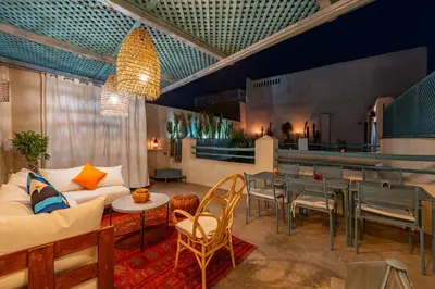 a living room with a couch and a table and chairs at Riad Dar Palma Heated Pool Jacuzzi Heart Of Marrakech Medina in Marrakech