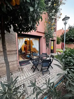 a patio with a table and chairs in front of a building at Dar Fayz in Marrakech