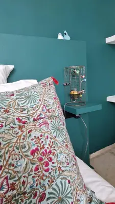 a bed with a colorful blanket and a bird cage at Riad Daba Chic in Marrakech