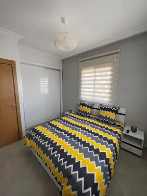 a bedroom with a black and yellow bed with a window at Brand new cozy apartment in Marrakech