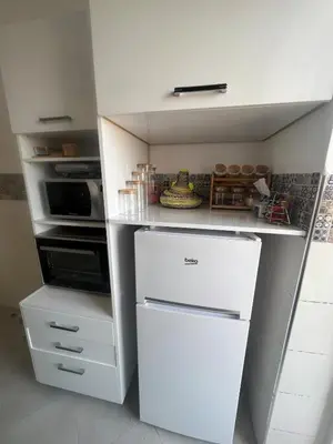 a kitchen with a white refrigerator and a microwave at Brand new cozy apartment in Marrakech