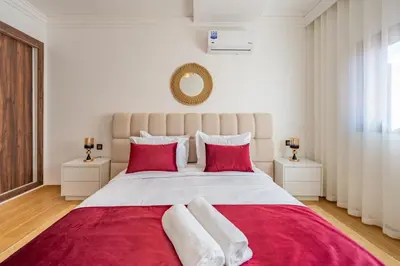 a bedroom with a large bed with red pillows at Appartement au coeur de Marrakech à côté de la gare avec piscine in Marrakech