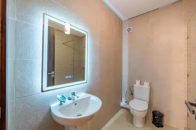 a bathroom with a sink and a toilet and a mirror at Appartement au coeur de Marrakech à côté de la gare avec piscine in Marrakech