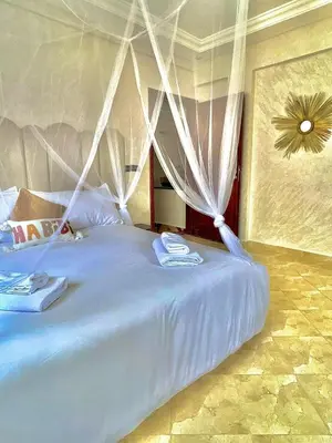 a bed with white drapes in a bedroom at Marrakech home in Marrakech
