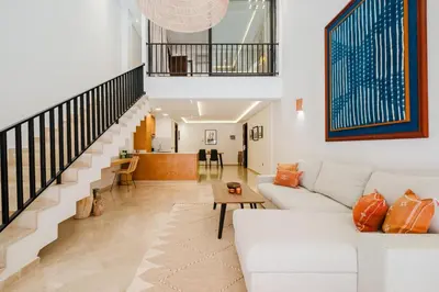 a living room with a white couch and a staircase at Duplex Style and Confortable au Centre de la Ville in Marrakech