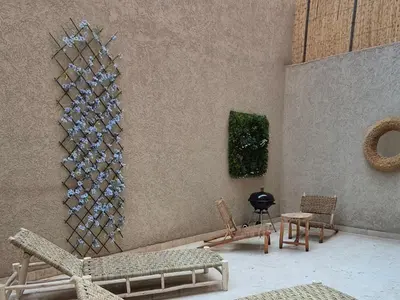 a room with chairs and a wall with wine glasses at Sérénité en plein Marrakech in Marrakech