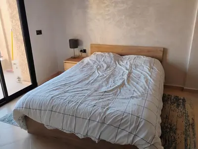 a bed in a bedroom with a white comforter at Home sweet home in Marrakech in Marrakech