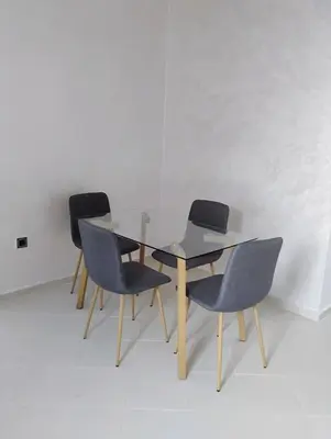 a glass table and four chairs in a room at Home sweet home in Marrakech in Marrakech