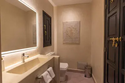 a bathroom with a sink and a toilet and a mirror at Riad Zehra in Marrakech