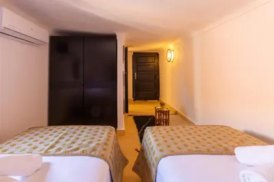 a hotel room with two beds and a hallway at Riad Zehra in Marrakech