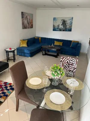 a living room with two tables and a blue couch at Cozy appartement en plein coeur de Guéliz in Marrakech