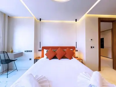 a bedroom with a large white bed with orange pillows at Appt de Luxe avec Terrasse,PiscinePartagée & wifi in Marrakech
