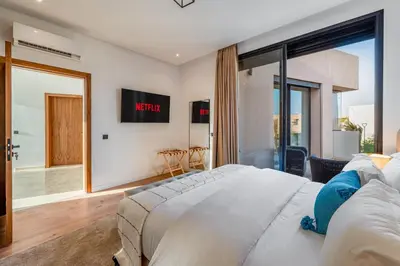 a bedroom with a large bed and a large window at Sumptuous Villa, Heated Pool, 15minutes to City Center, Daily Housekeeping, Private Cook and Chauffeur, Games in Marrakech
