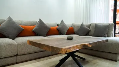 a living room with a couch and a wooden coffee table at Appartement de luxe au cœur du quartier majorelle in Marrakech