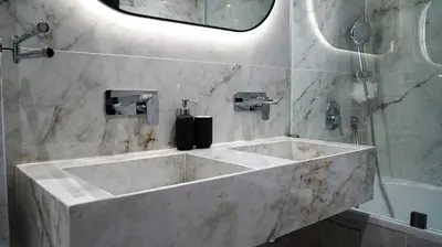 a marble bathroom with a large sink and a shower at Appartement de luxe au cœur du quartier majorelle in Marrakech