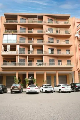 a large building with cars parked in a parking lot at The Modern Luxury - Marrakech in Marrakech