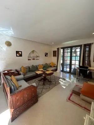 a living room with a couch and a table at Maison à la Palmeraie avec piscine et parking à Marrakech in Marrakech