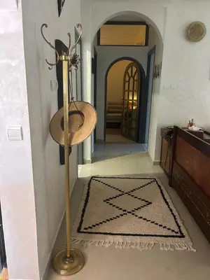 a hallway with a floor rug and a floor lamp at Maison à la Palmeraie avec piscine et parking à Marrakech in Marrakech