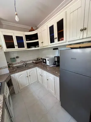 a kitchen with white cabinets and a stainless steel refrigerator at Maison à la Palmeraie avec piscine et parking à Marrakech in Marrakech