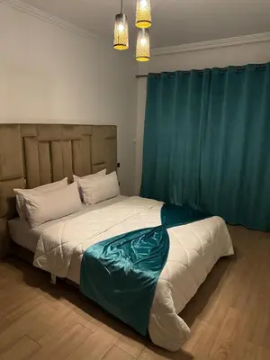a bedroom with a large bed with blue curtains at Apartment piscine gueliz hivernage ctm train aeroport supratour in Marrakech