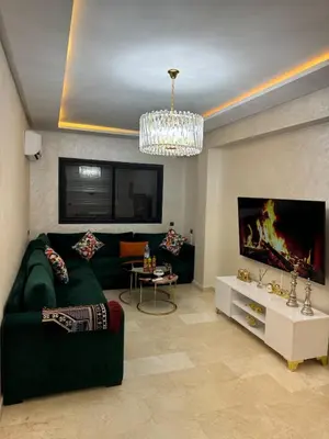 a living room with a green couch and a tv at Apartment piscine gueliz hivernage ctm train aeroport supratour in Marrakech